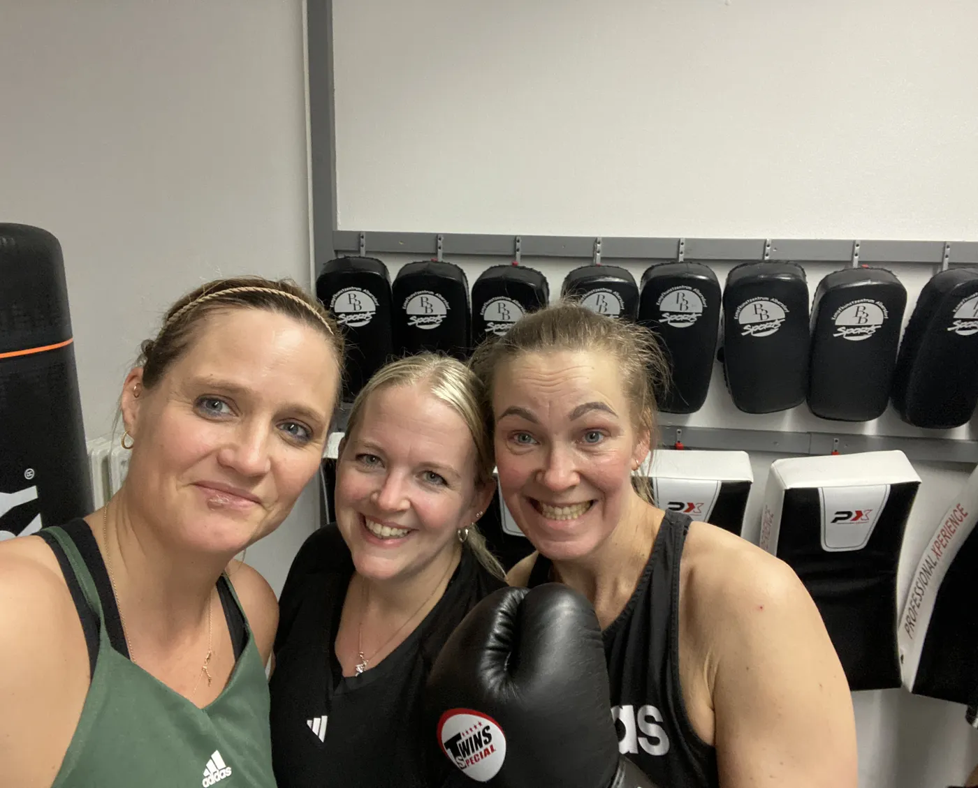 Drei Teilnehmerinnen machen nach dem Training ein Selfie vor der Pratzenwand