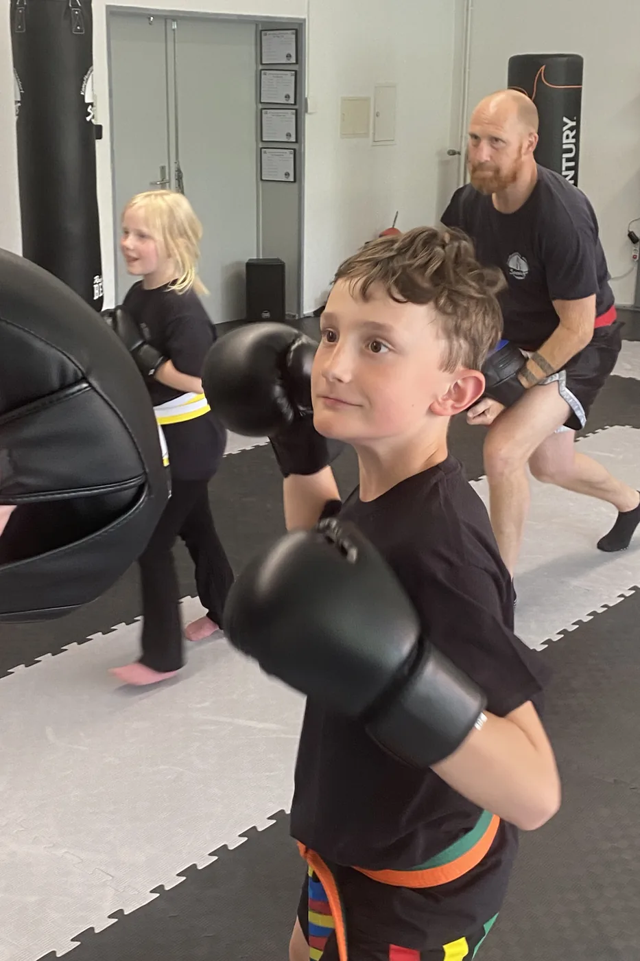 Junge mit Boxhandschuhen in Deckung beim Thaiboxen-Training