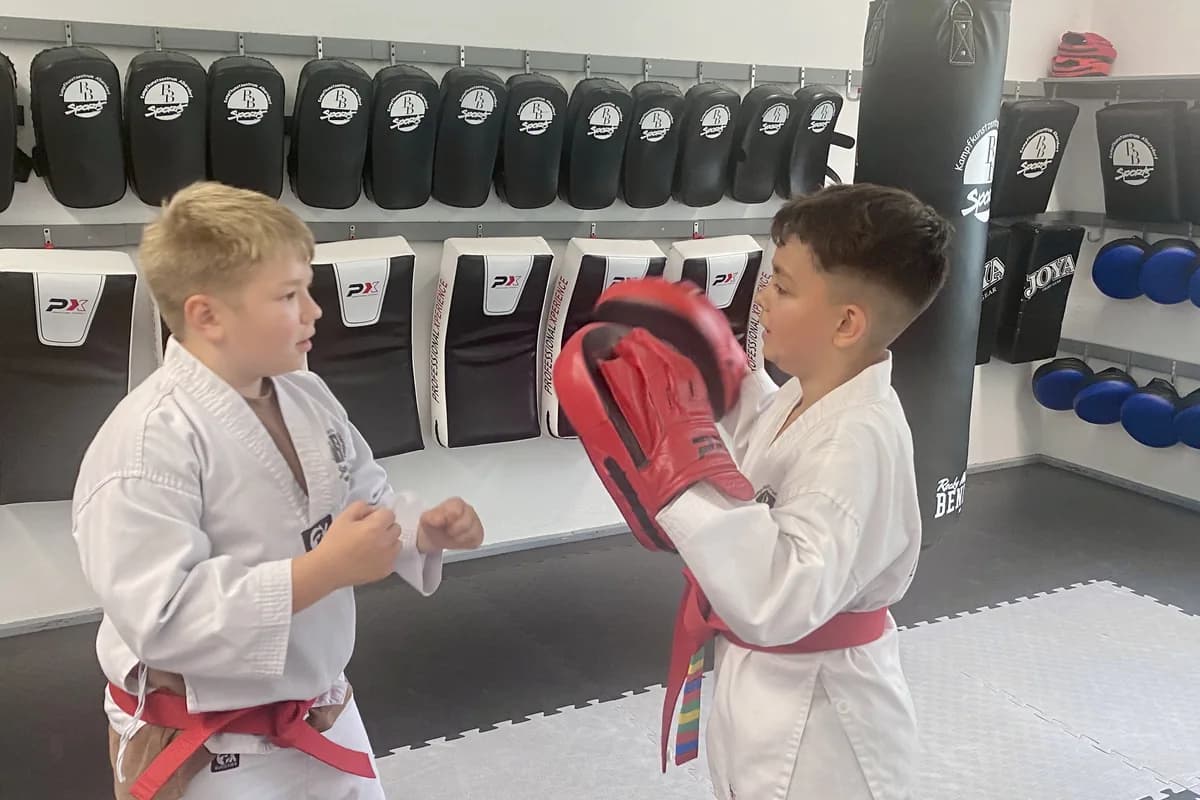Zwei Jungen trainieren im Partnertraining mit der Pratze
