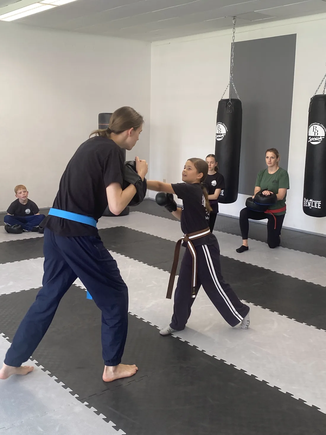 Jugendliche schlägt im Krav-Maga-Training auf die Pratze der Trainerin