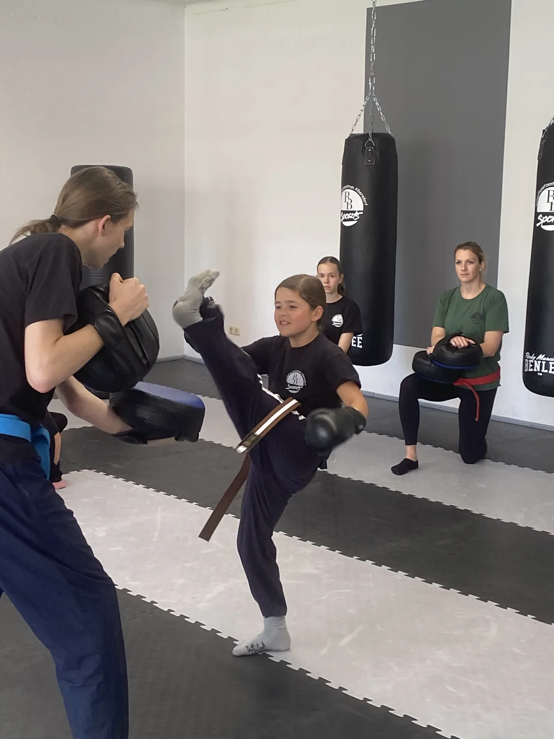 Jugendliche tritt hoch gegen das Schlagpolster des Trainers