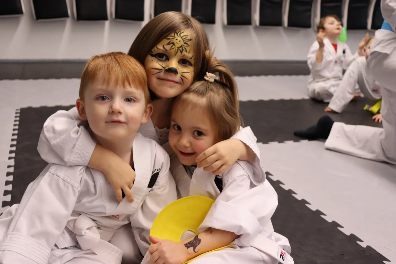 Zwei Minis-Kinder umarmen sich fröhlich beim Training